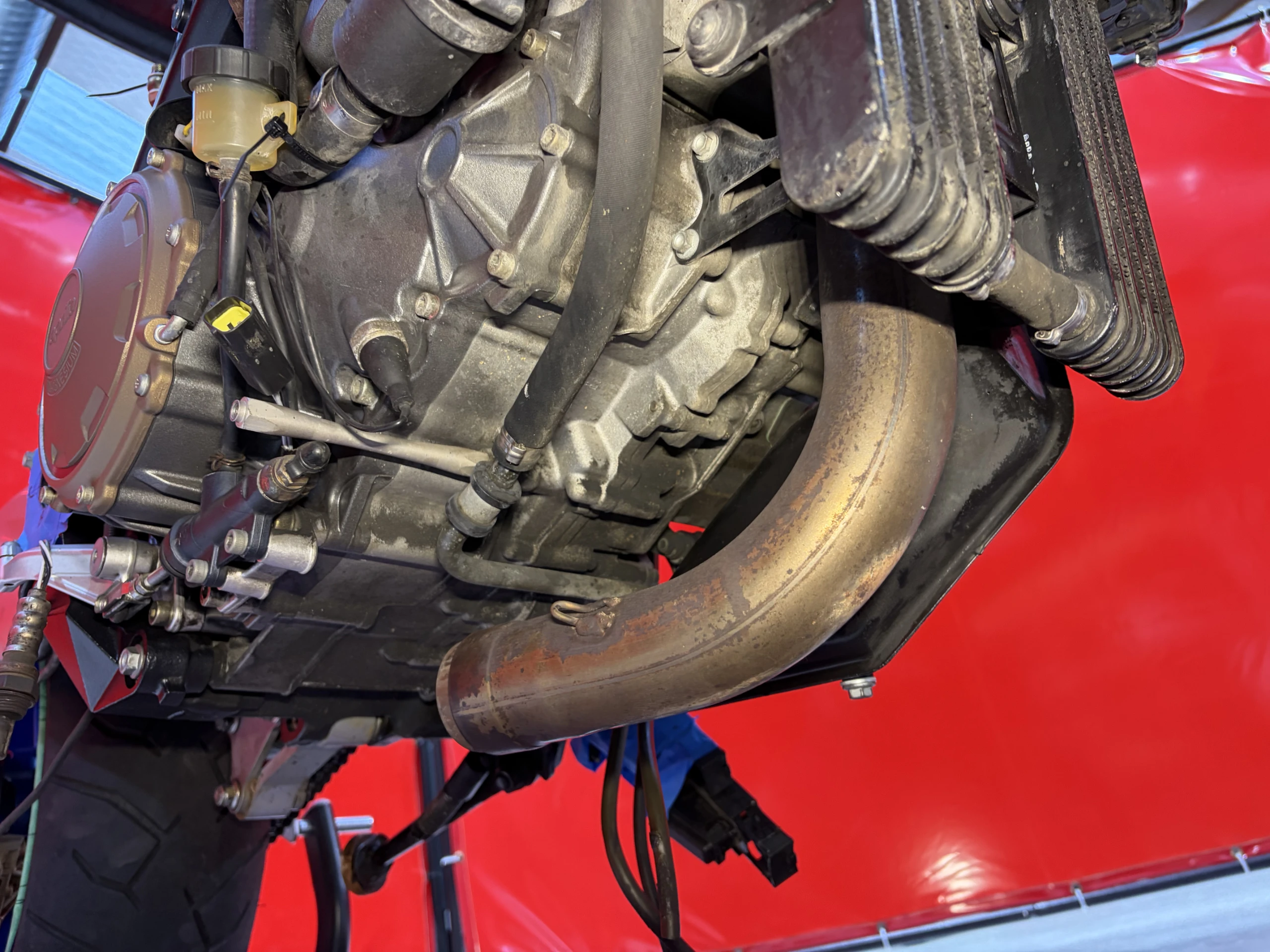 2005 Aprilia RSV1000R sump, header run and engine belly before dry ice cleaning, covered in chain fling and baked-on oil mist