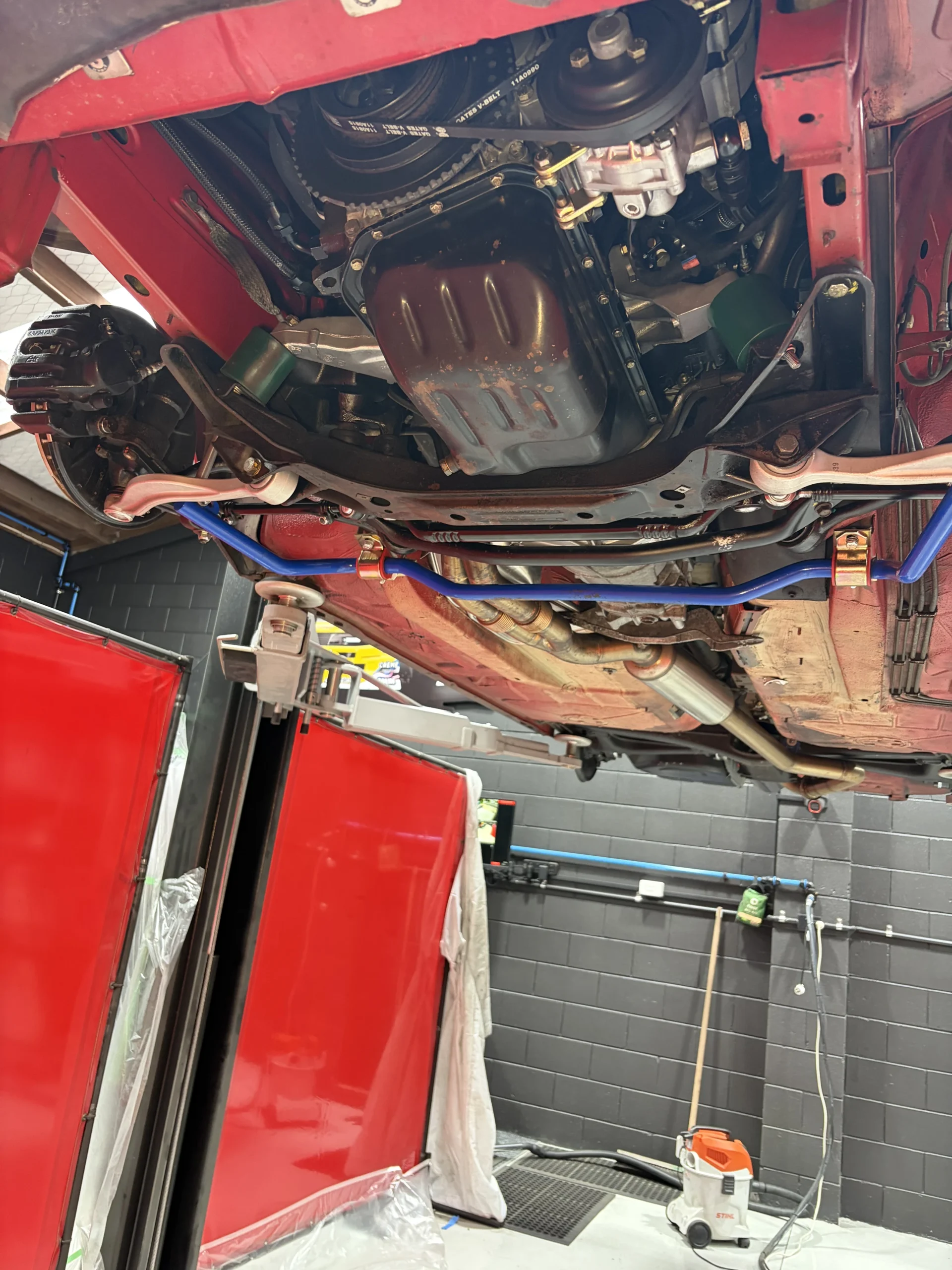 BMW E28 front subframe, sump guard and anti-roll bar after dry ice blasting, clean and dry with factory finishes intact