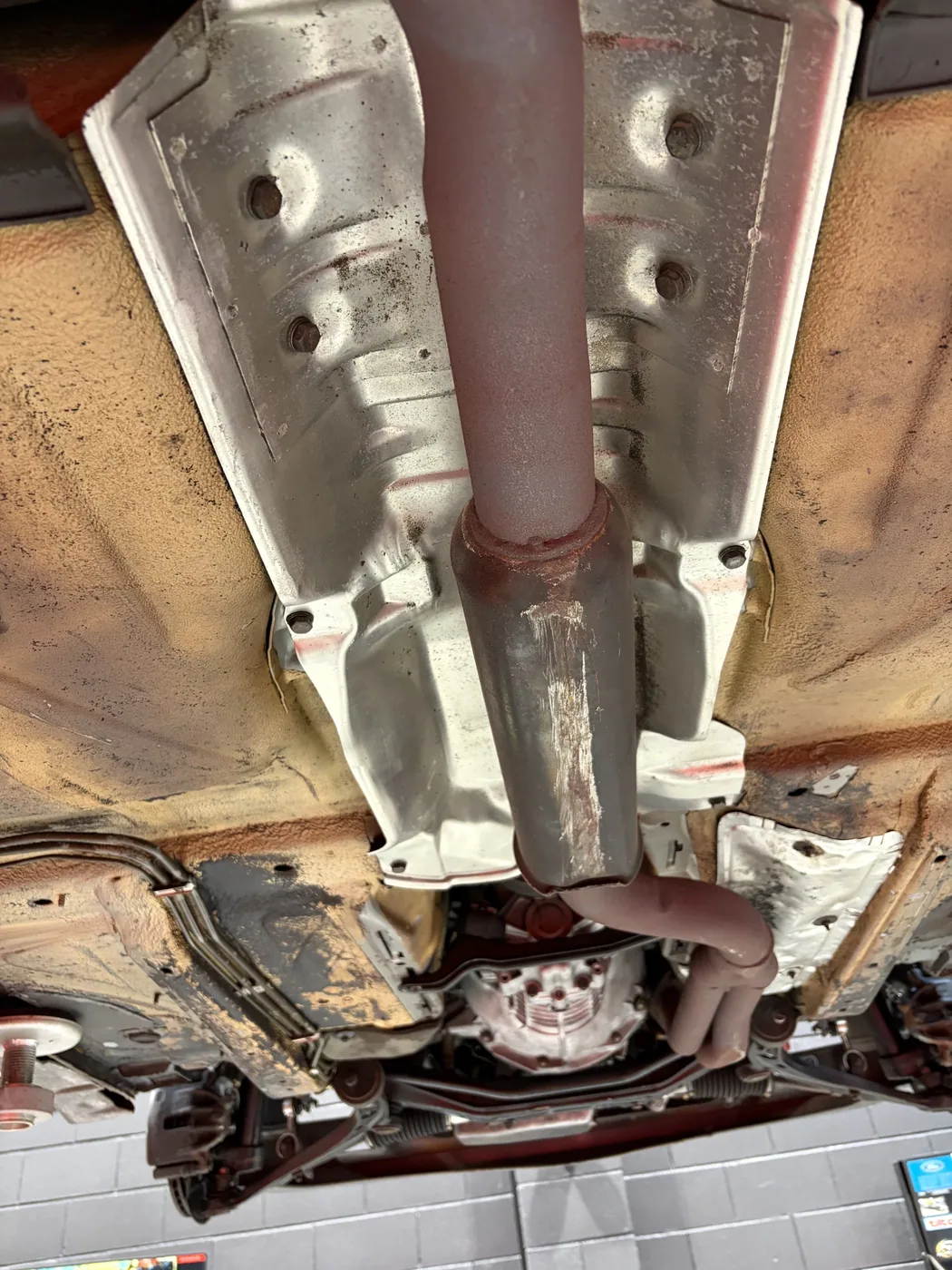 BMW E30 M-Tech 1 exhaust run and heat shields after dry ice blasting, clean and dry with underseal intact
