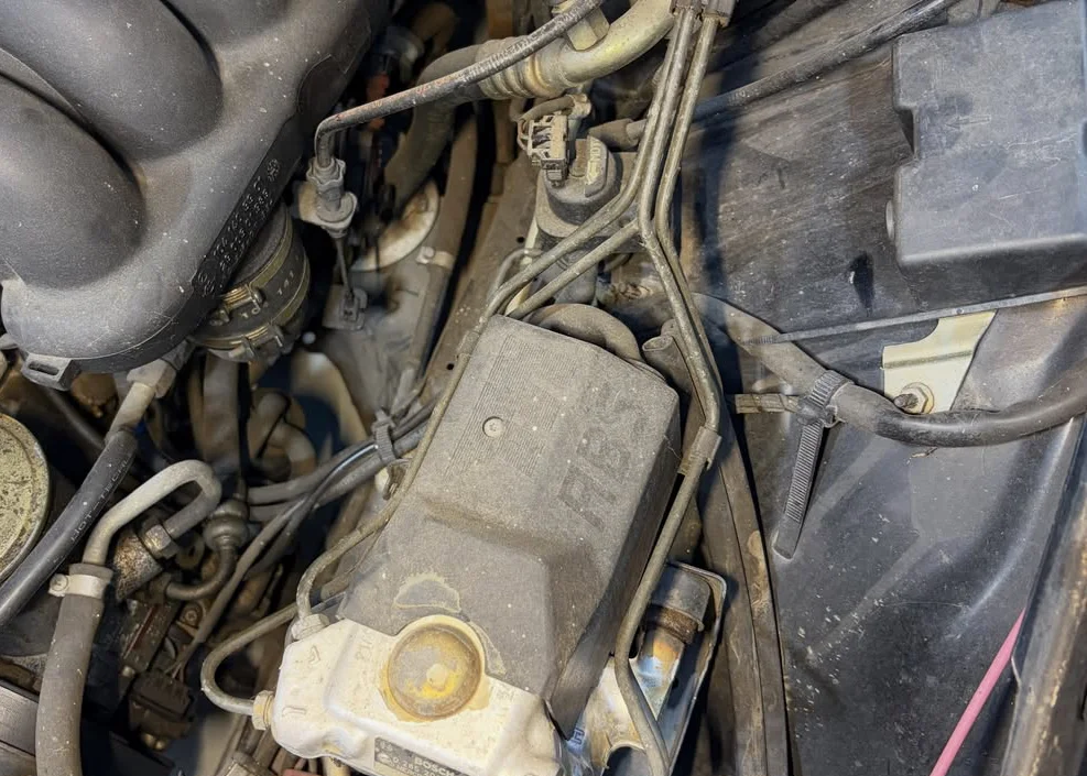 Engine bay before dry ice cleaning, coated in grime