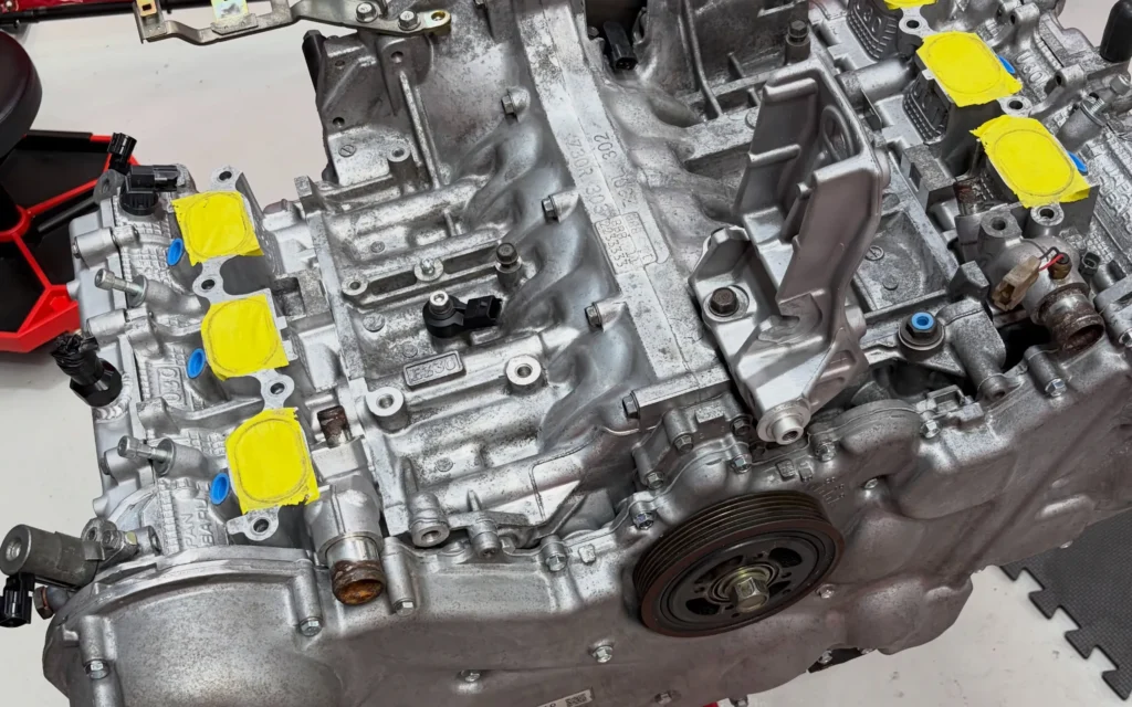 Engine on a stand with yellow caps masking the openings