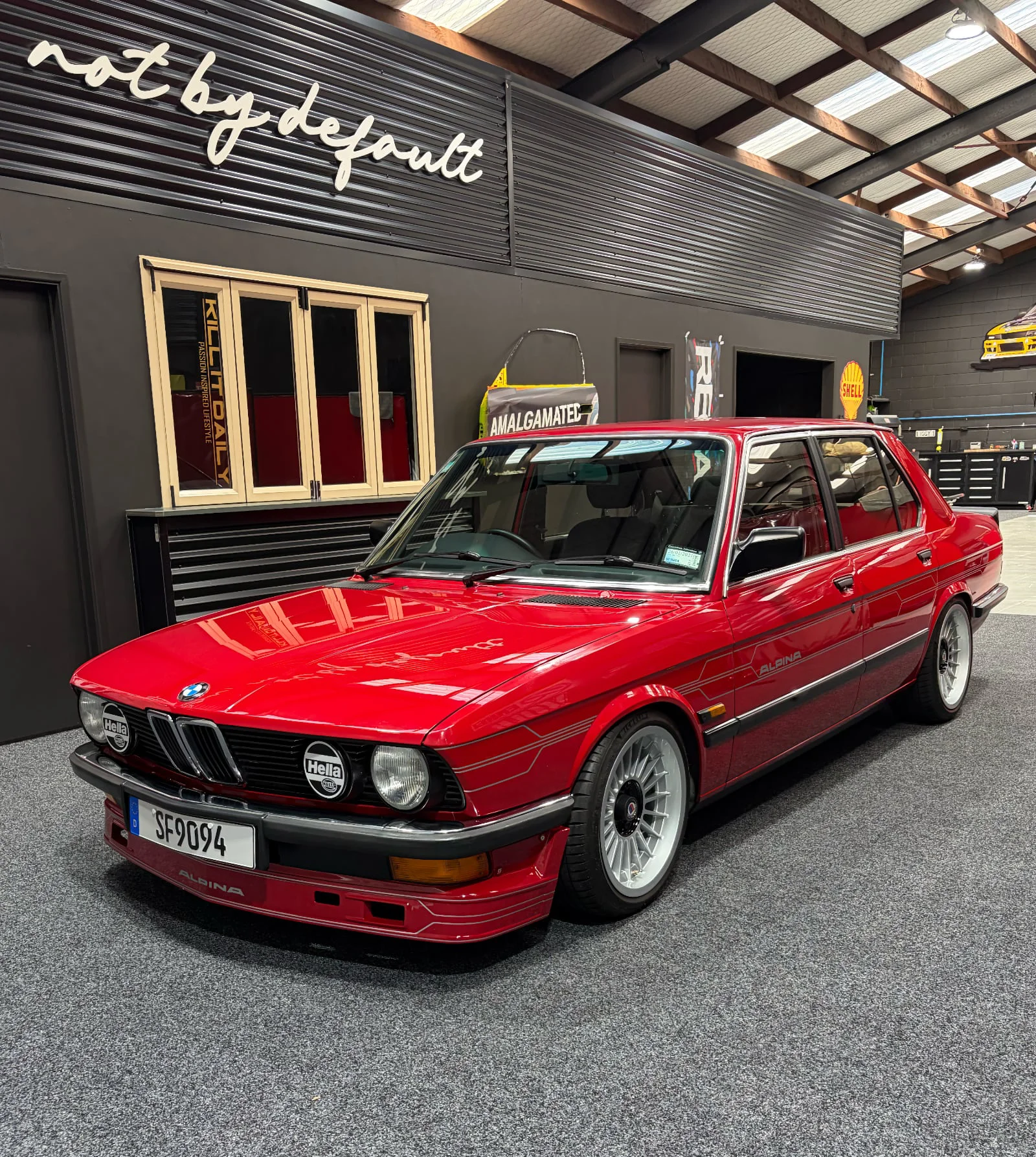 Red BMW E28 parked in a workshop